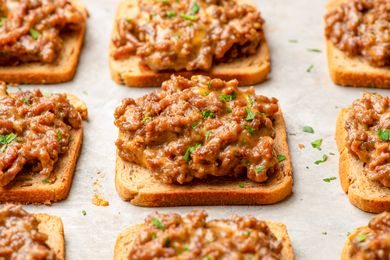 Openfaced rye toast topped with seasoned ground beef and cheese mixture garnished with herbs part of a recipe for Hanky Panky snacks