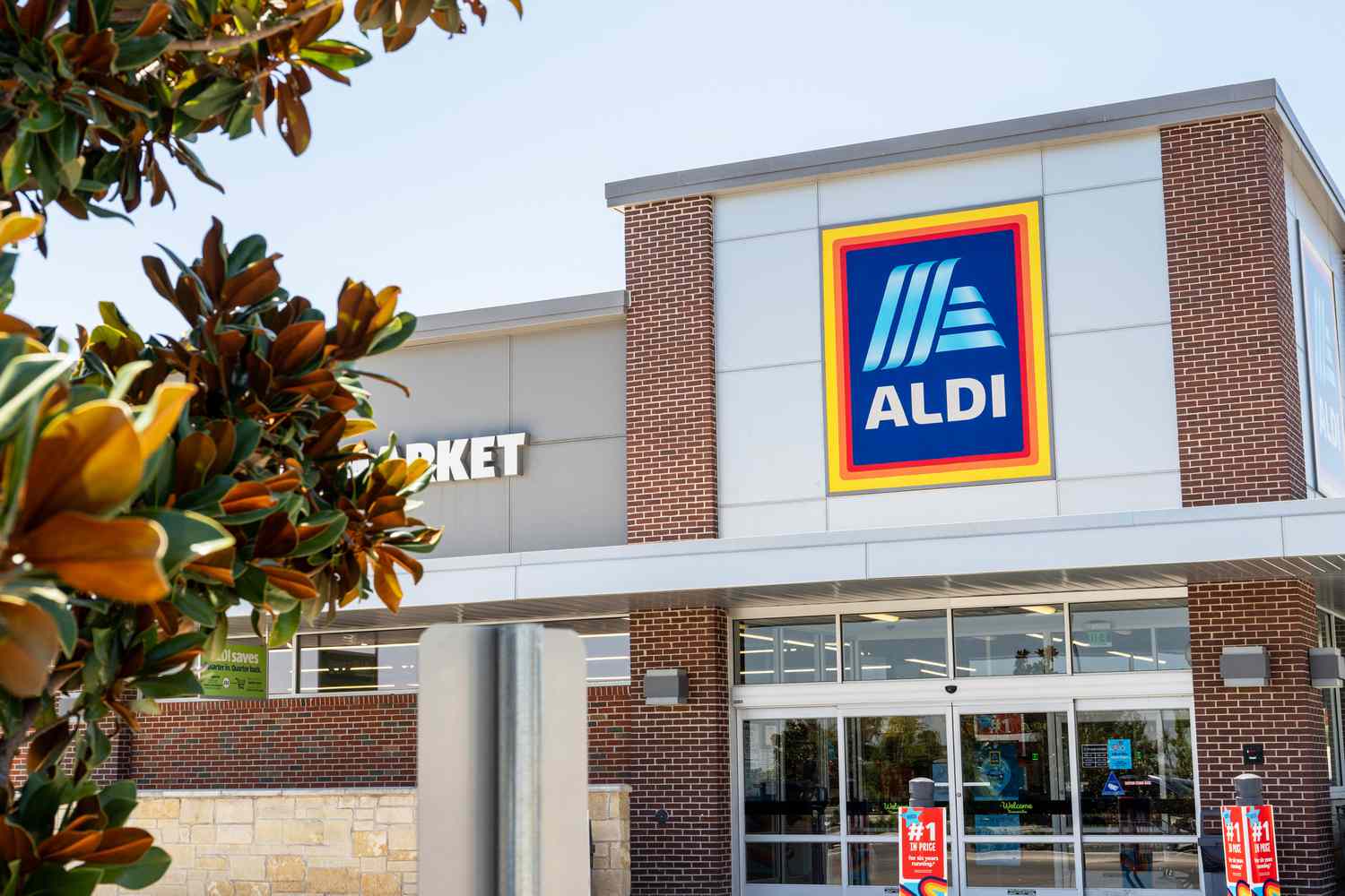 A view of the storefront of an Aldi supermarket, showing signs and the entrance