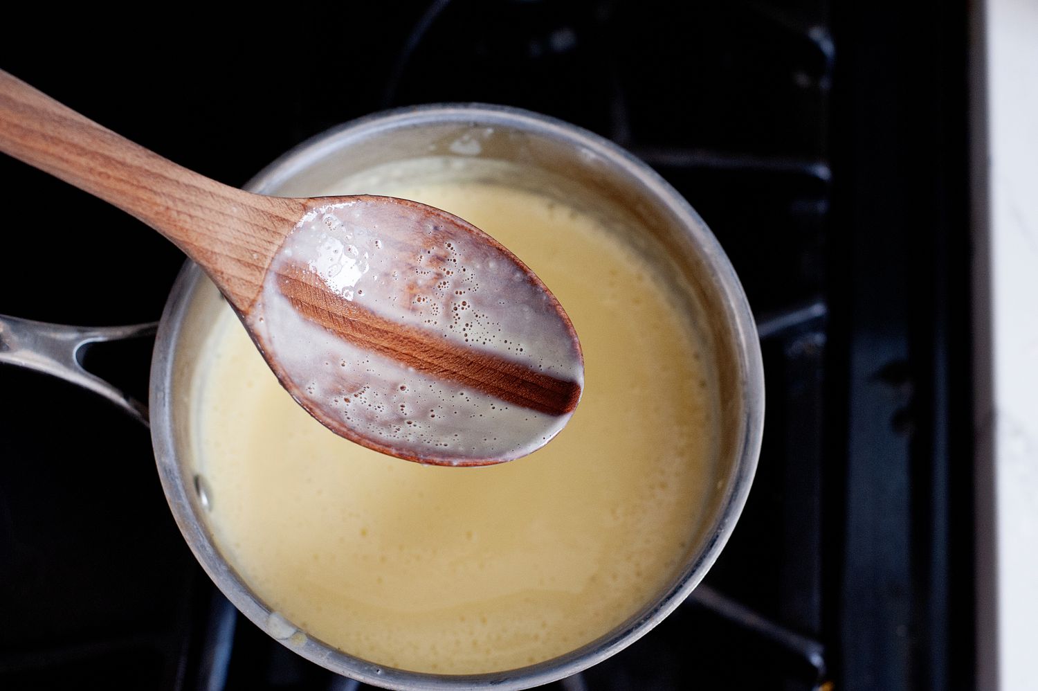 Thickened mint chocolate chip ice cream base in a sauce pan.