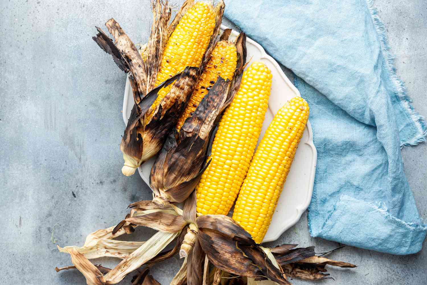 A Platter of Grilled Sweet Corn with Husks Partially Removed