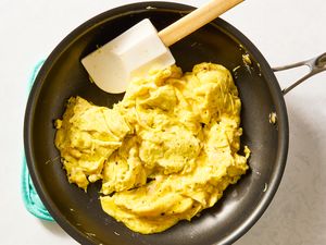 Scrambled eggs in a frying pan with a spatula