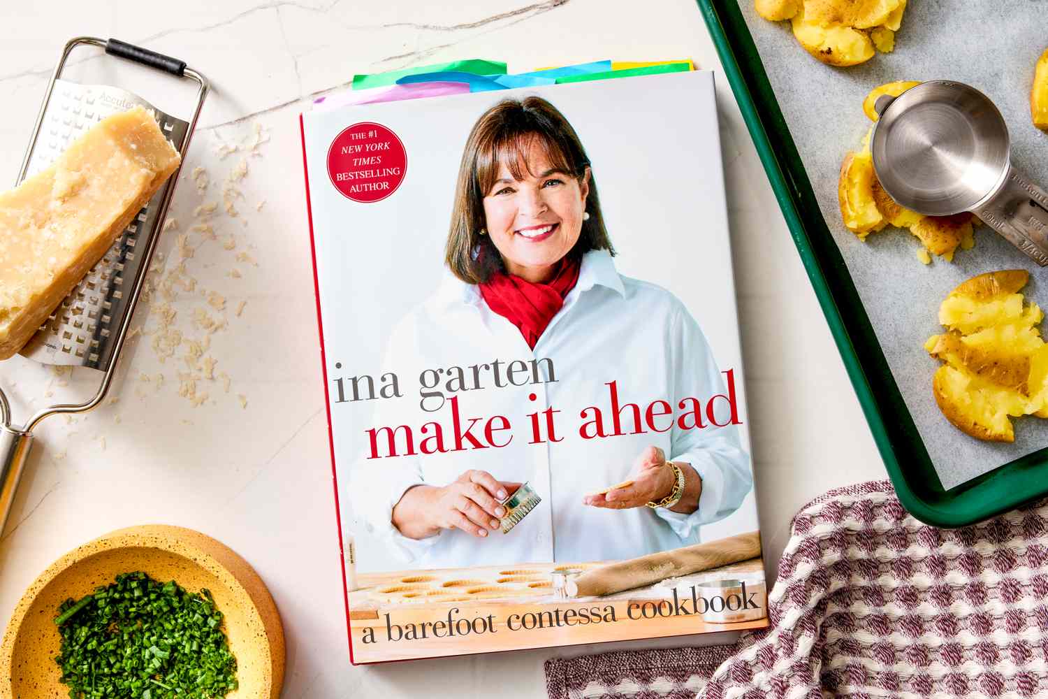 Ina Gartens cookbook titled Make It Ahead displayed on a table with cooking ingredients