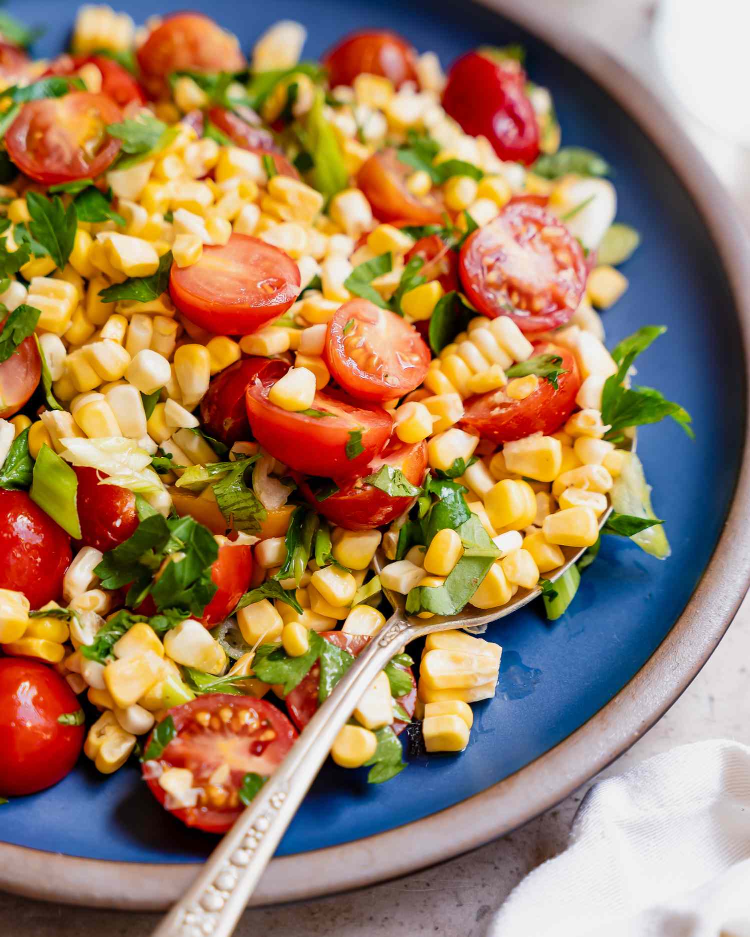 Corn and tomato salad with fresh herbs on a plate