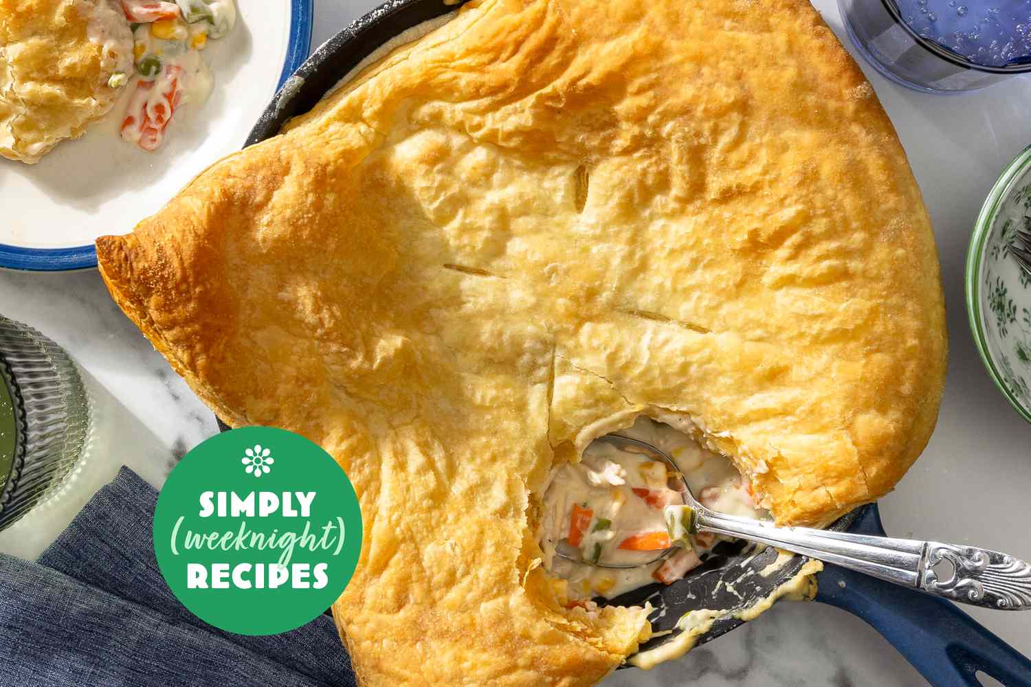 A pot pie with a serving removed plated nearby