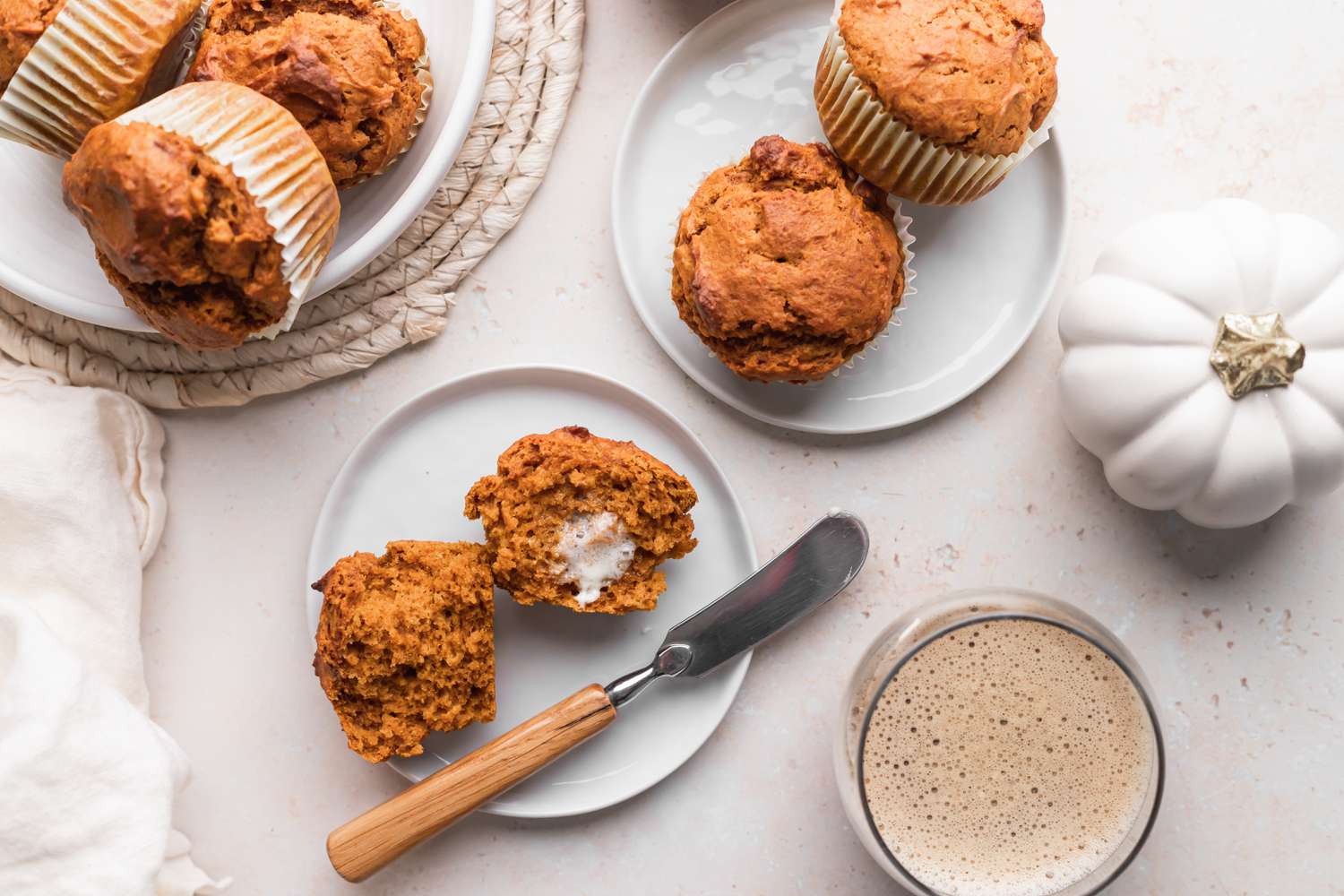 Overhead view of plates with buttered basic pumpkin muffins.