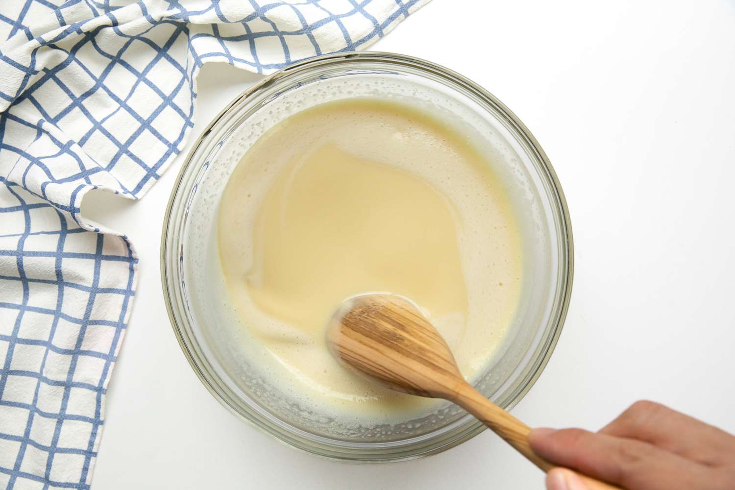 Three Kinds of Milks, Coconut, and Cassava Mixed into Egg-Sugar Mixture Using a Spoon for Bibingkang Kamoteng Kahoy