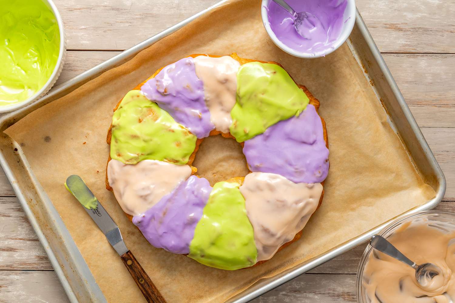 green, purple, and white icing added to the king cake