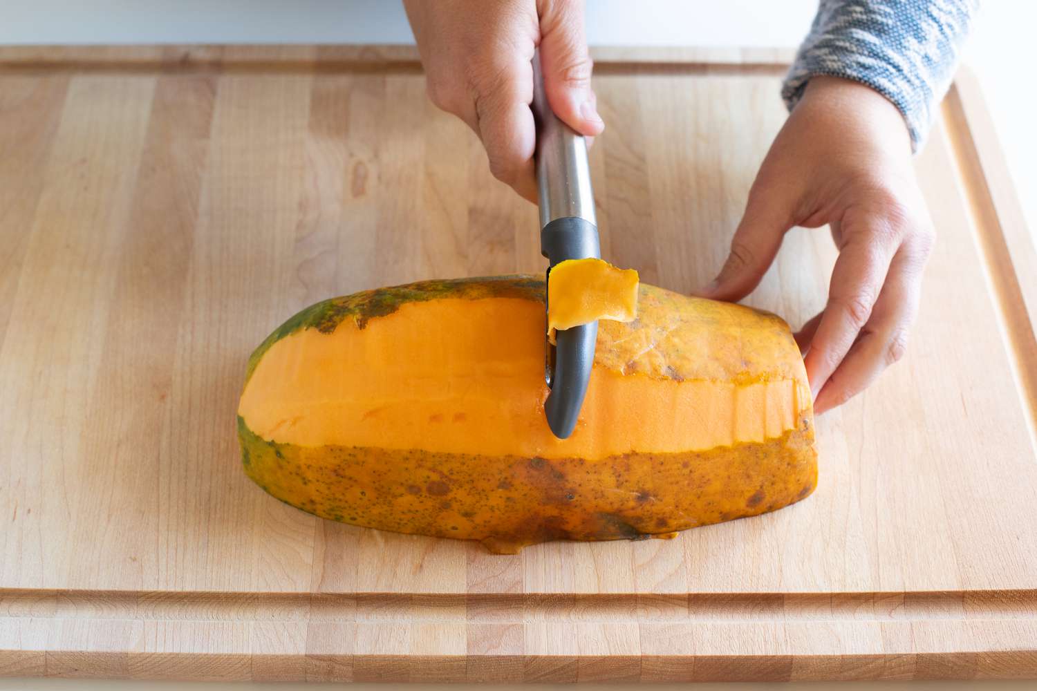Peeling the skin off a papaya