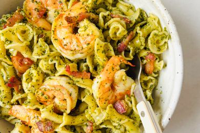 Shrimp pasta with pesto and a fork in a bowl