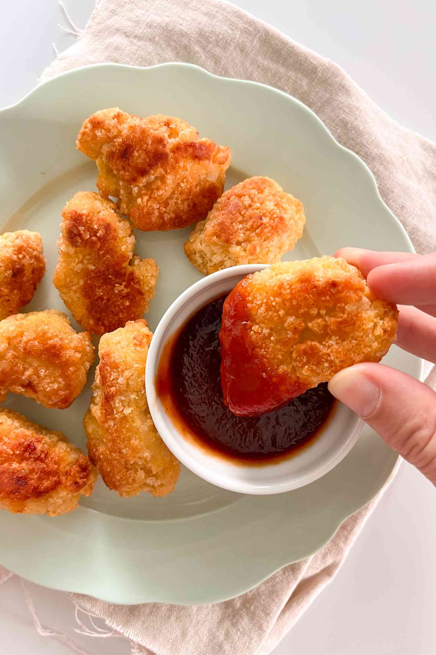 Chicken nugget dipped in a small bowl of ketchup