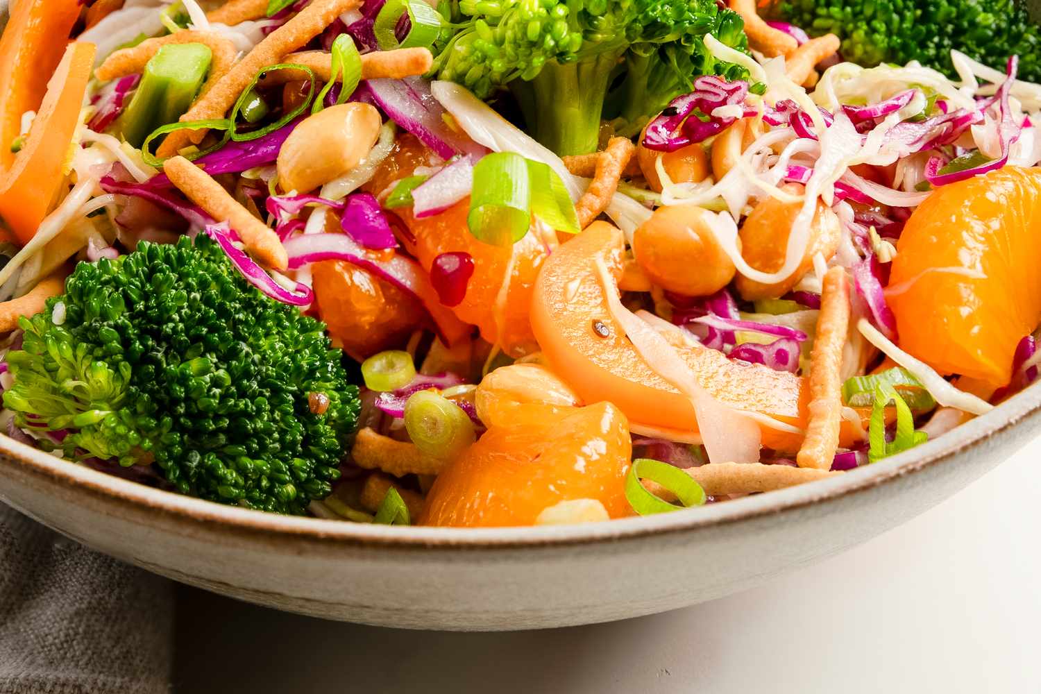 A bowl of broccoli crunch salad with vegetables mandarins and nuts