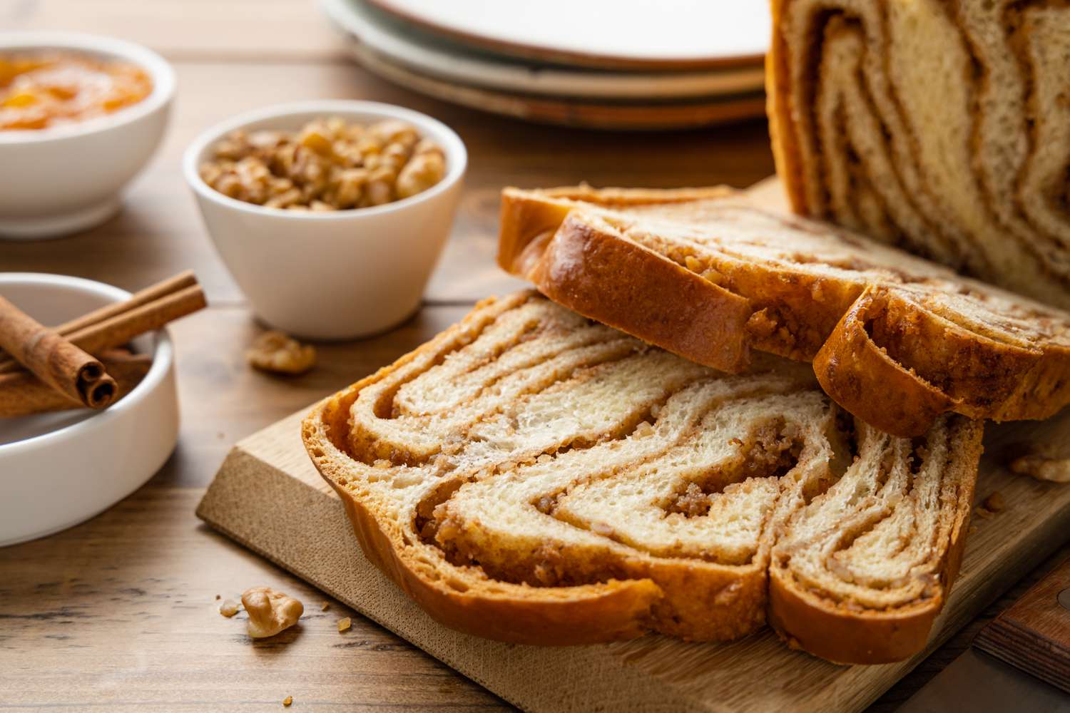 Slices of Povitica Next to a Loaf on a Cutting Board