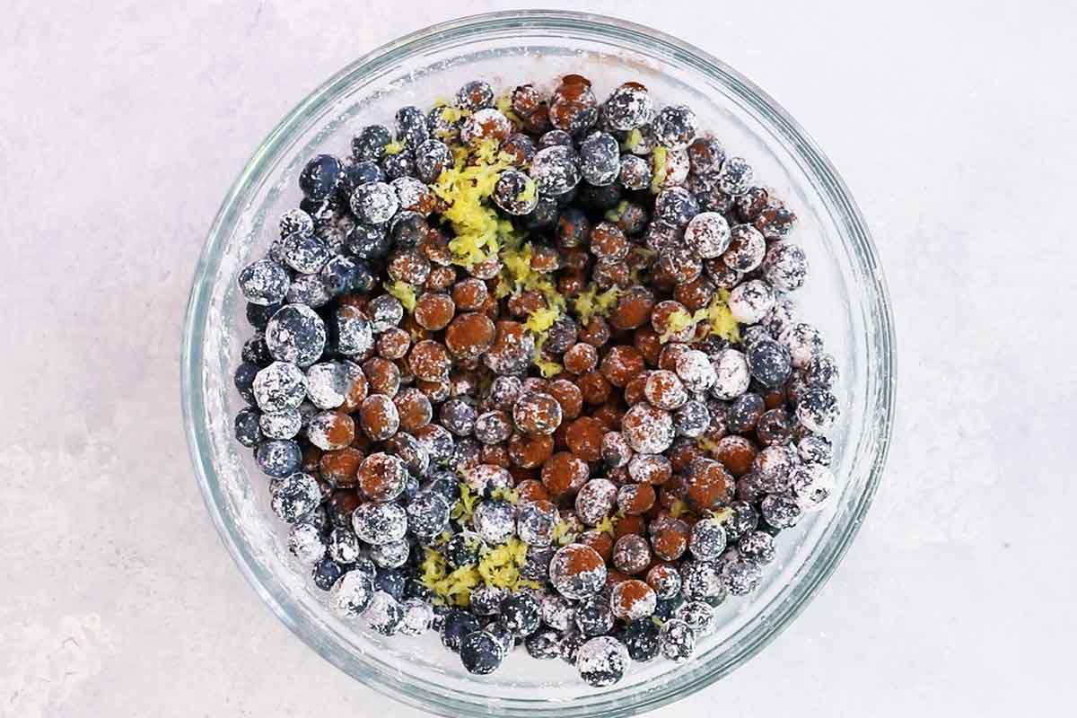 Blueberries covered in spices and seasoning resting in a glass bowl