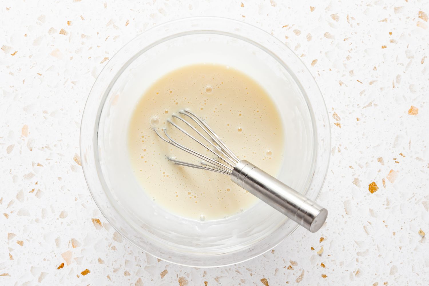 Condensed Milk and Milk Whisked Together in a Bowl for Thai Iced Tea Recipe
