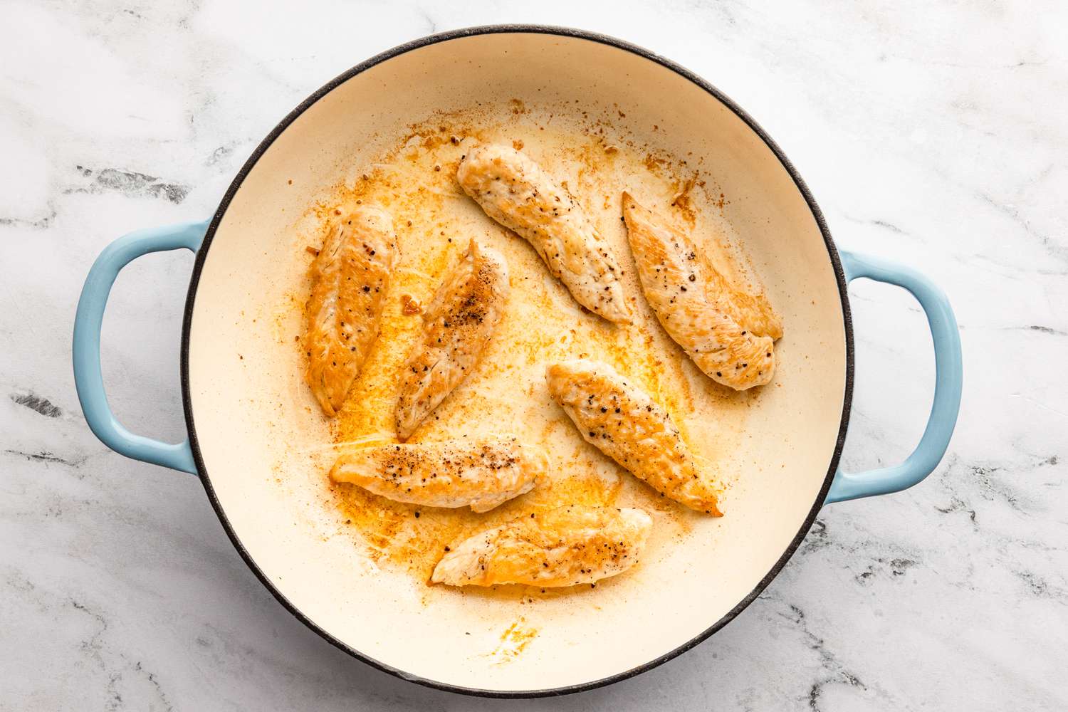 chicken breast tenderloins cooking in a pan for chicken caesar pasta recipe