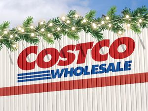 Costco Wholesale storefront with light string and festive greenery on top