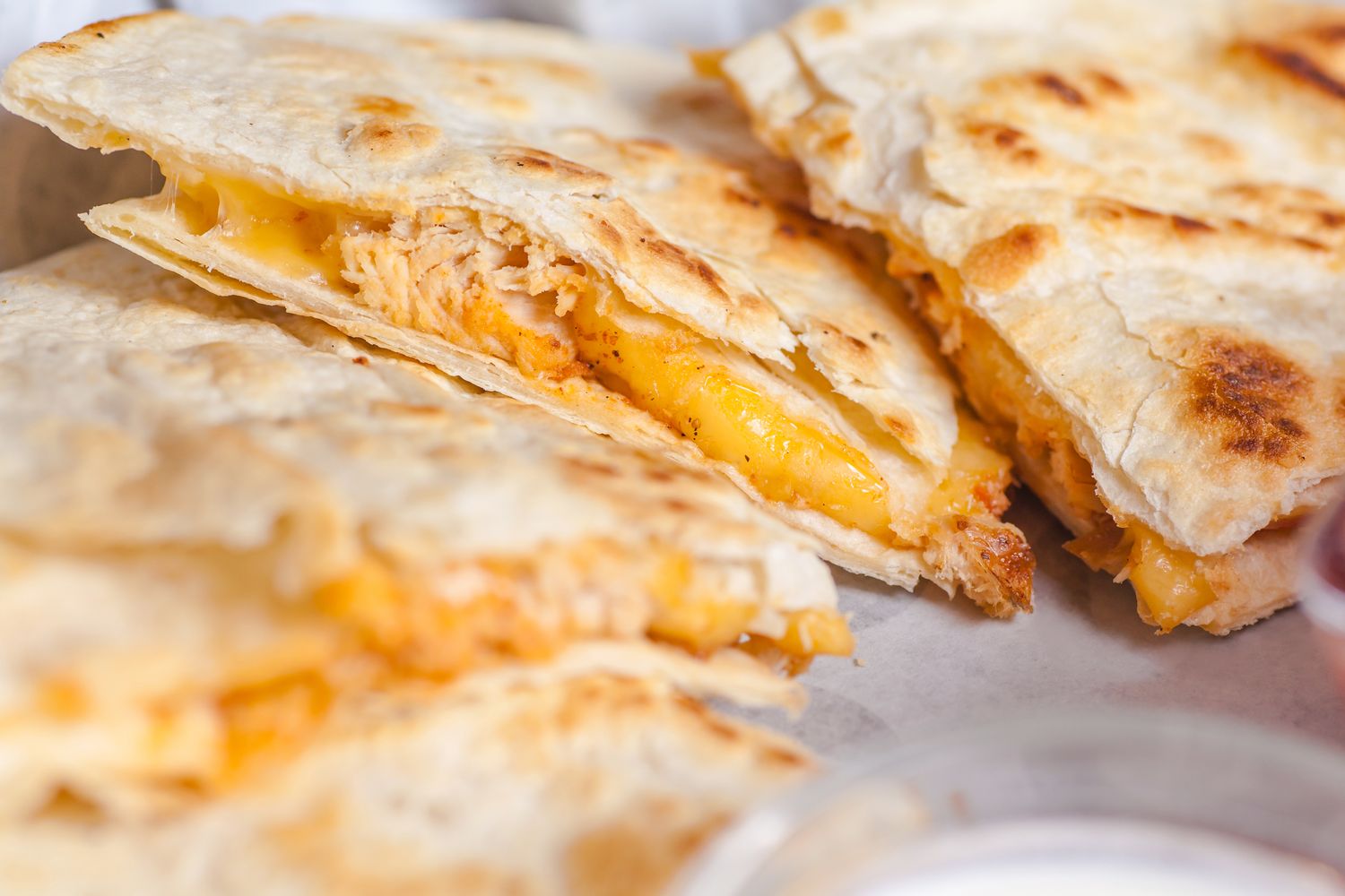 A closeup of sliced quesadillas filled with melted cheese and cooked chicken