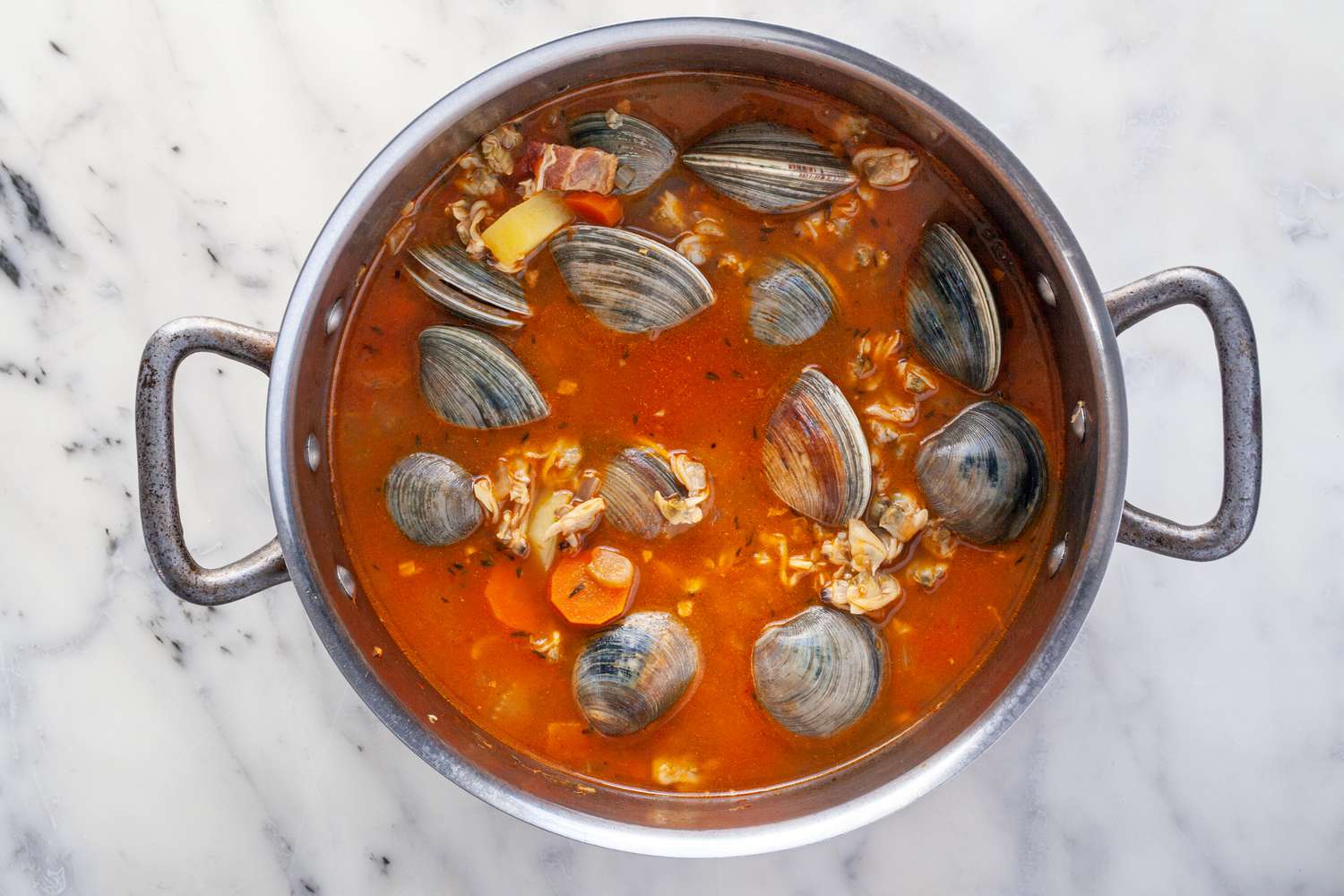 Manhattan Clam Chowder with fresh clams in the shell added to the pot