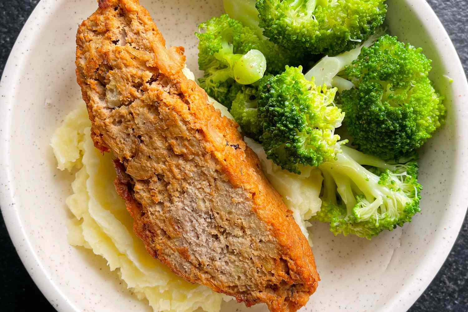 Ina Garten's meatloaf recipe served with mashed potatoes and broccoli