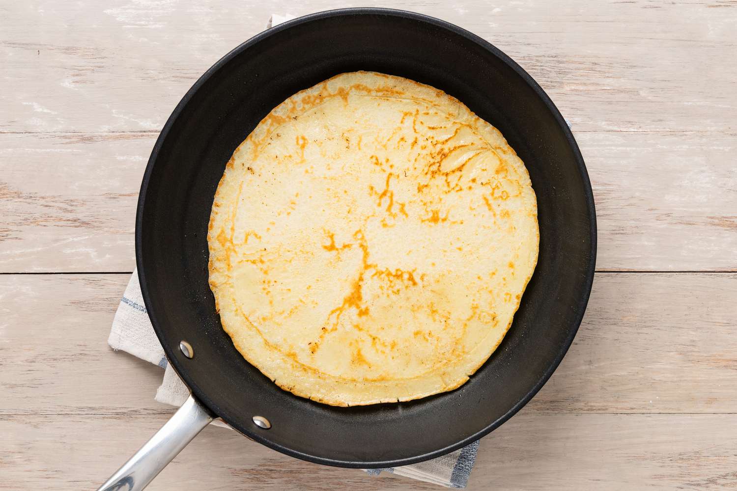 Pannenkoeken (Dutch Pancakes) flipped on the skillet