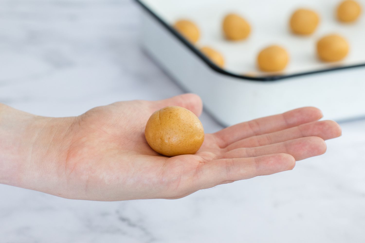 Rolling Peanut Butter Cookies in a ball.