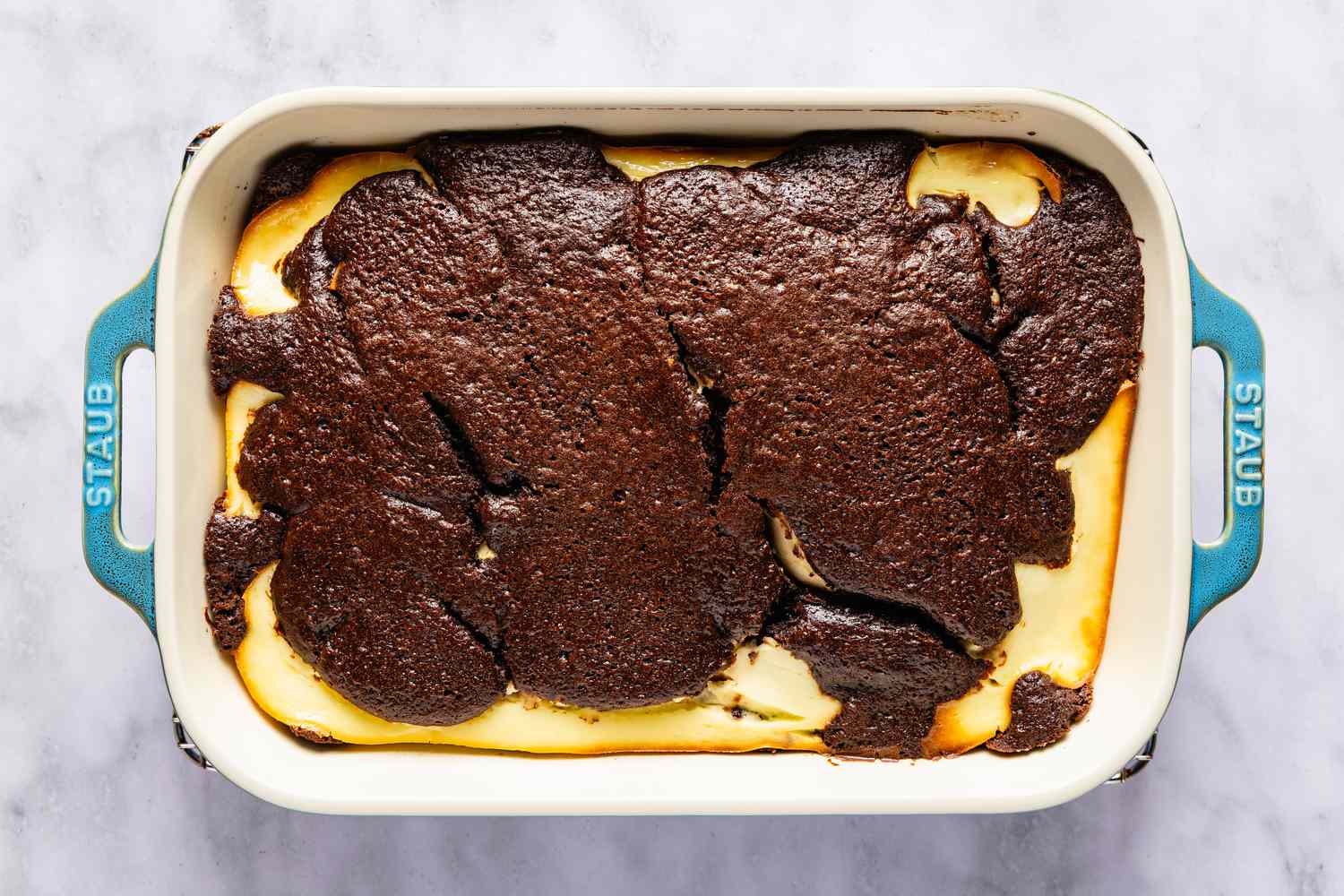 Baked dish of Italian love cake in a rectangular baking dish with visible chocolate and ricotta cheese layers