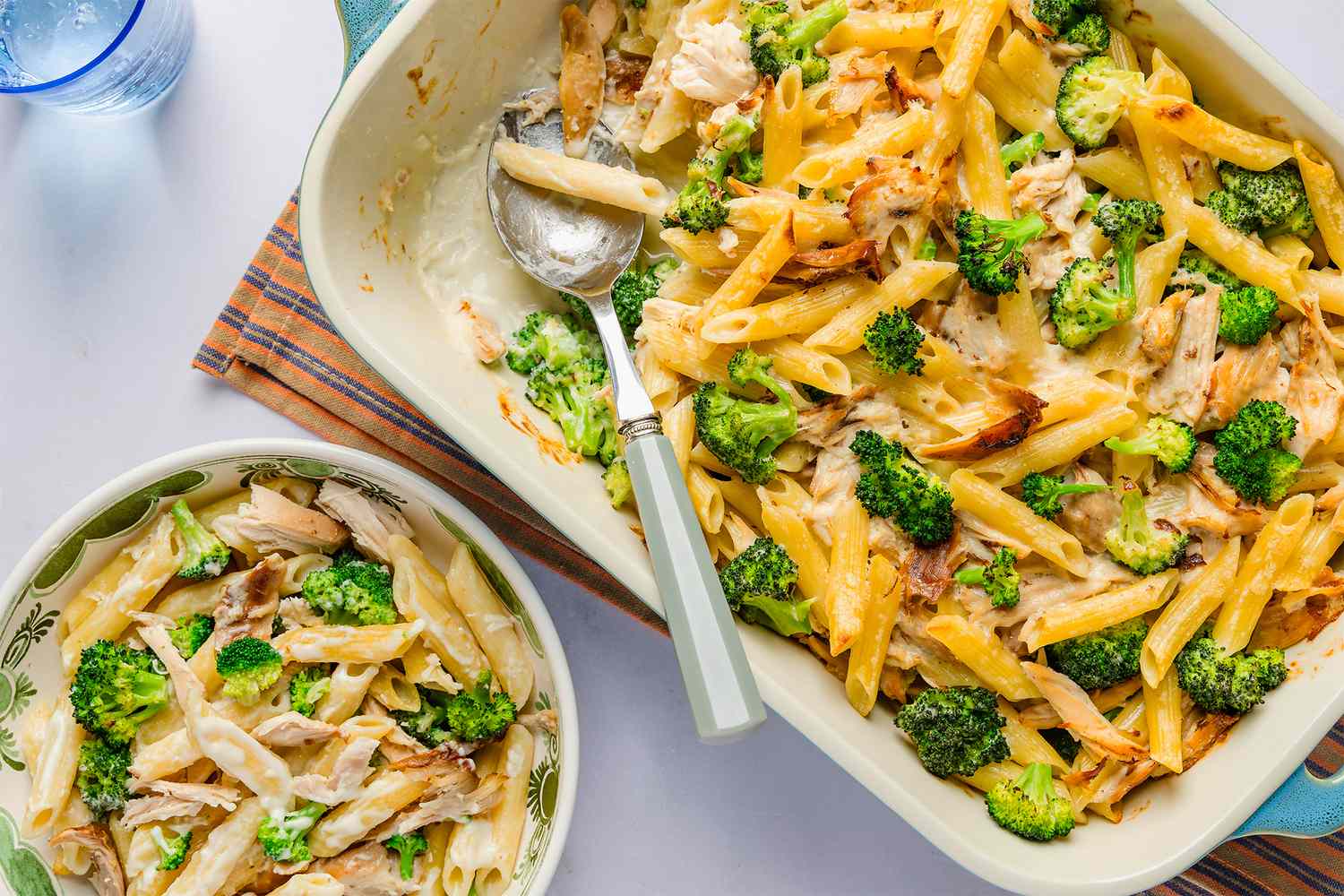 Chicken Alfredo pasta bake with broccoli served in a dish and a bowl