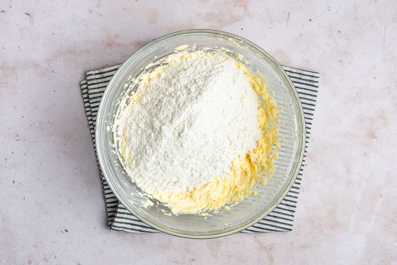 Dry ingredients added to a bowl with thumbprint cookie batter 