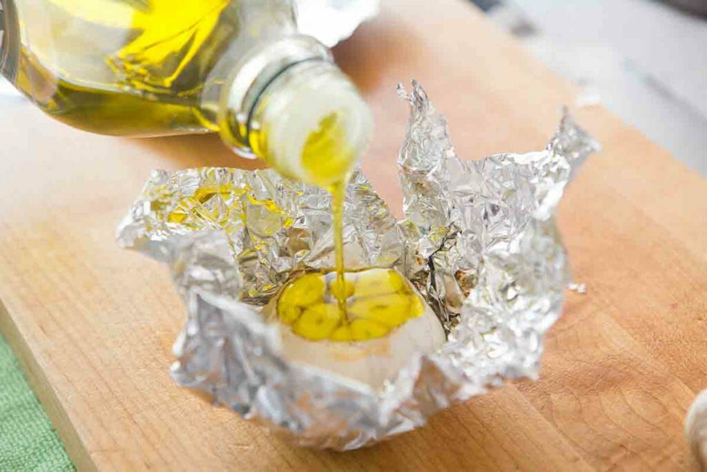 slice top off of garlic head, pour over with olive oil