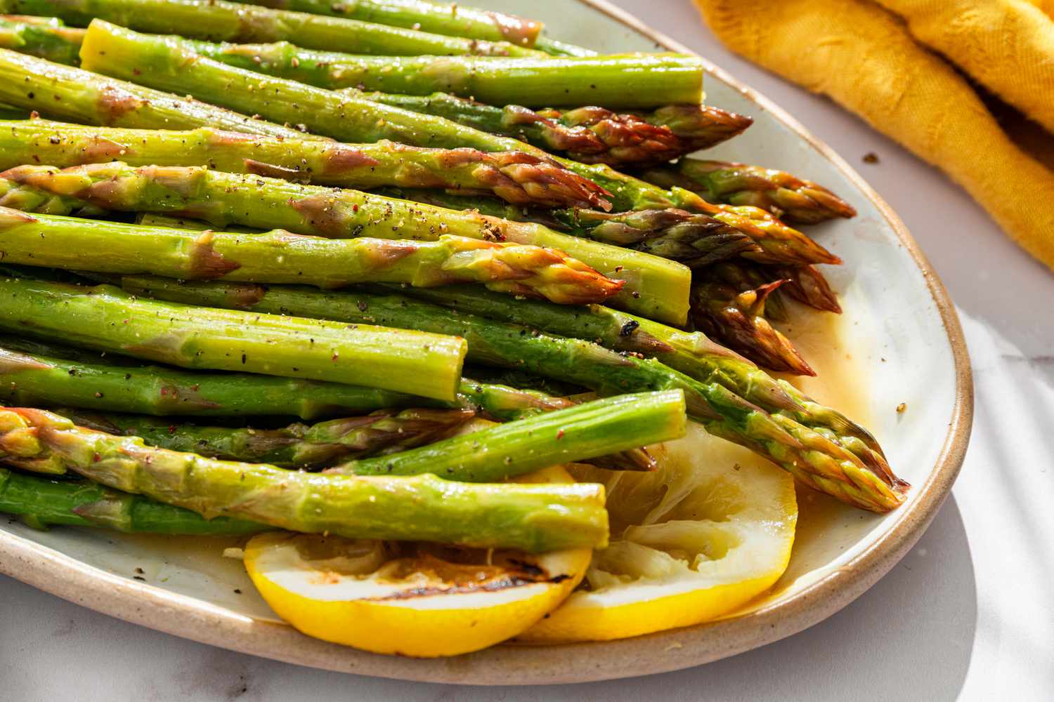 Grilled asparagus on a plate with lemon slices