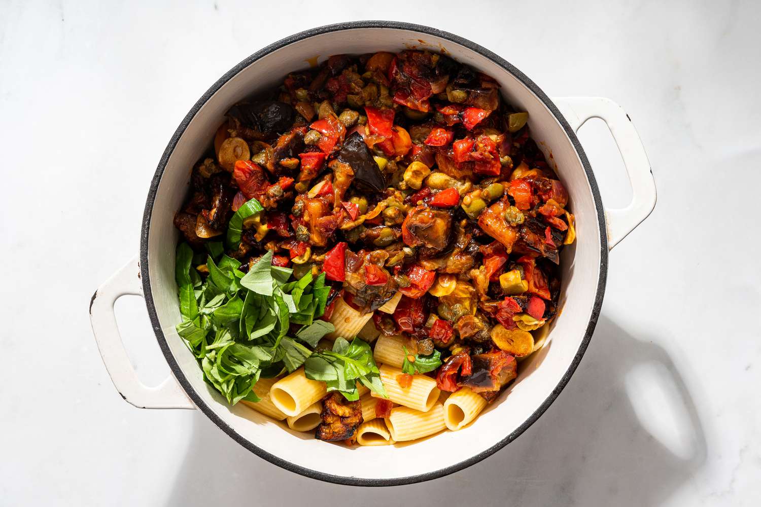 roasted vegetables, basil, and pasta in a dutch oven for caponata pasta recipe 