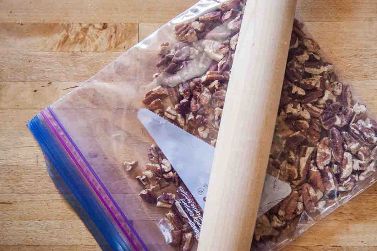 Crushing pecans in a zipper bag with a rolling pin