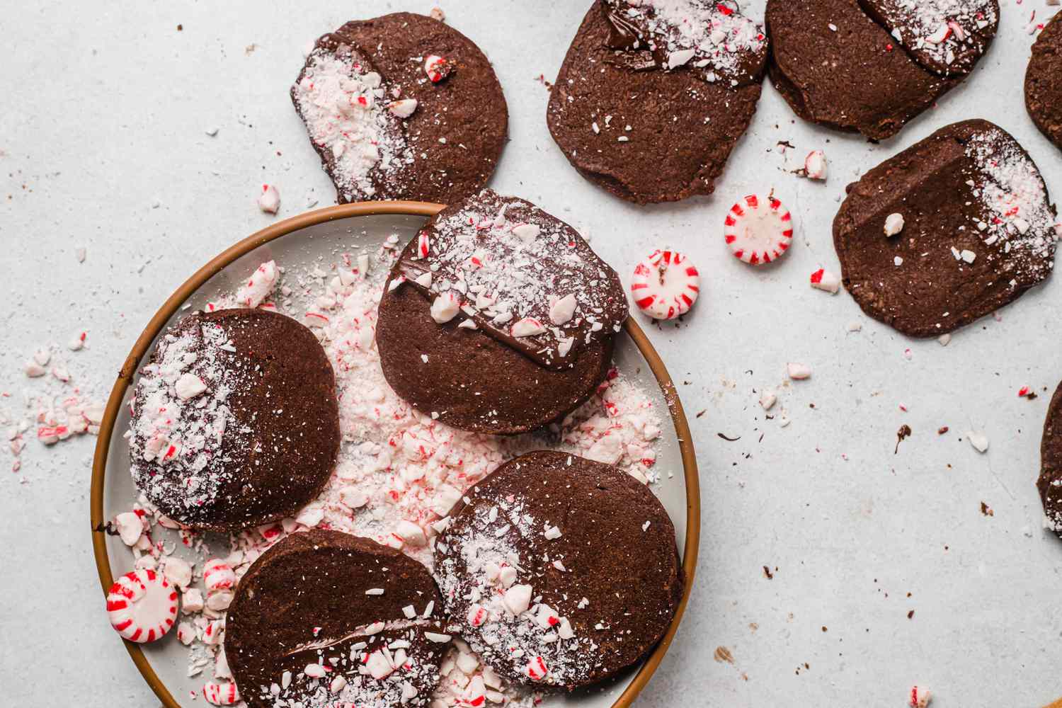 Overhead view of holiday chocolate and peppermint shortbread on a platter with crushed peppermint around it.