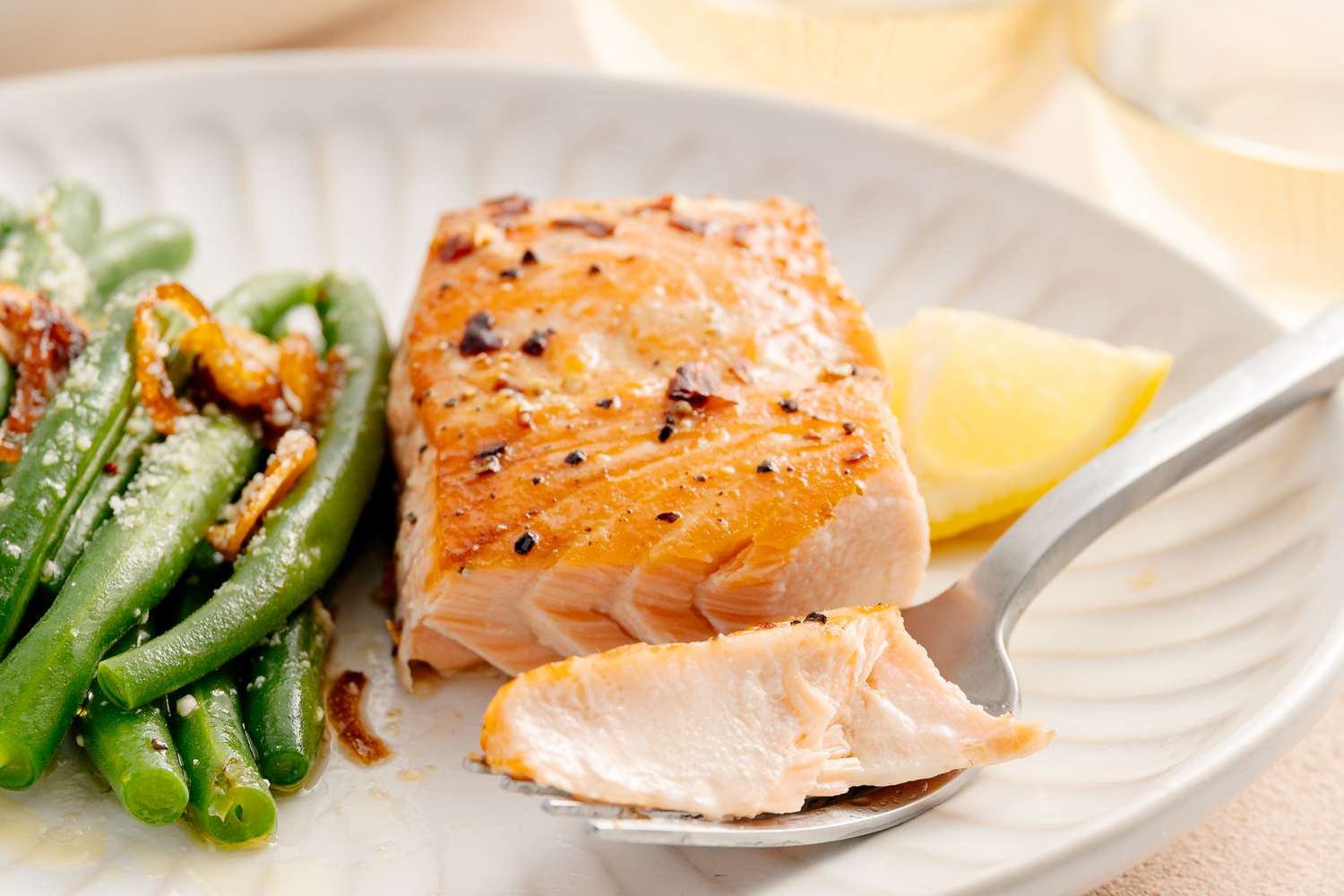 Plate of Salmon Filet with Brown Sugar Glaze and a Side of Green Beans. Some of Salmon Is on the Fork.