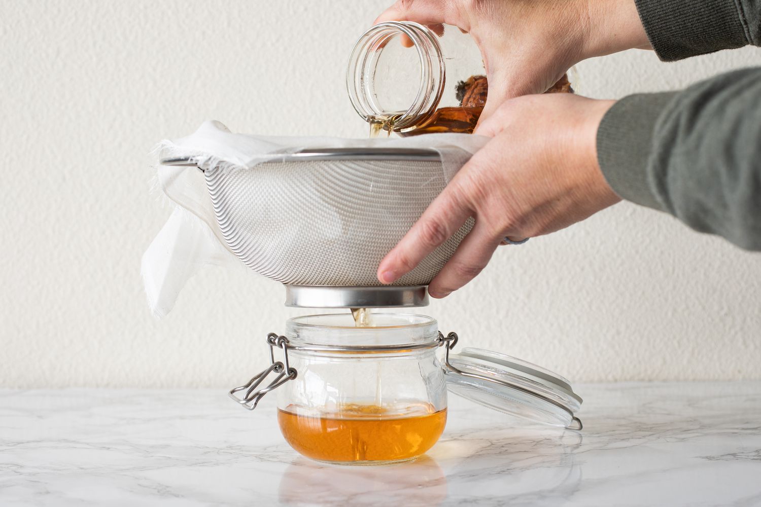 Adding infusion into glass mason jar for liqueur