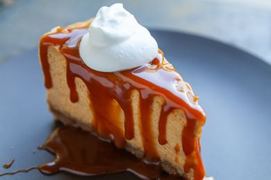 pumpkin cheesecake slice with caramel and whipped cream