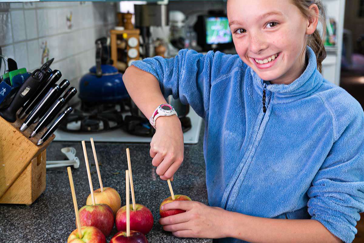 Caramel Apples Recipe putting sticks into apples