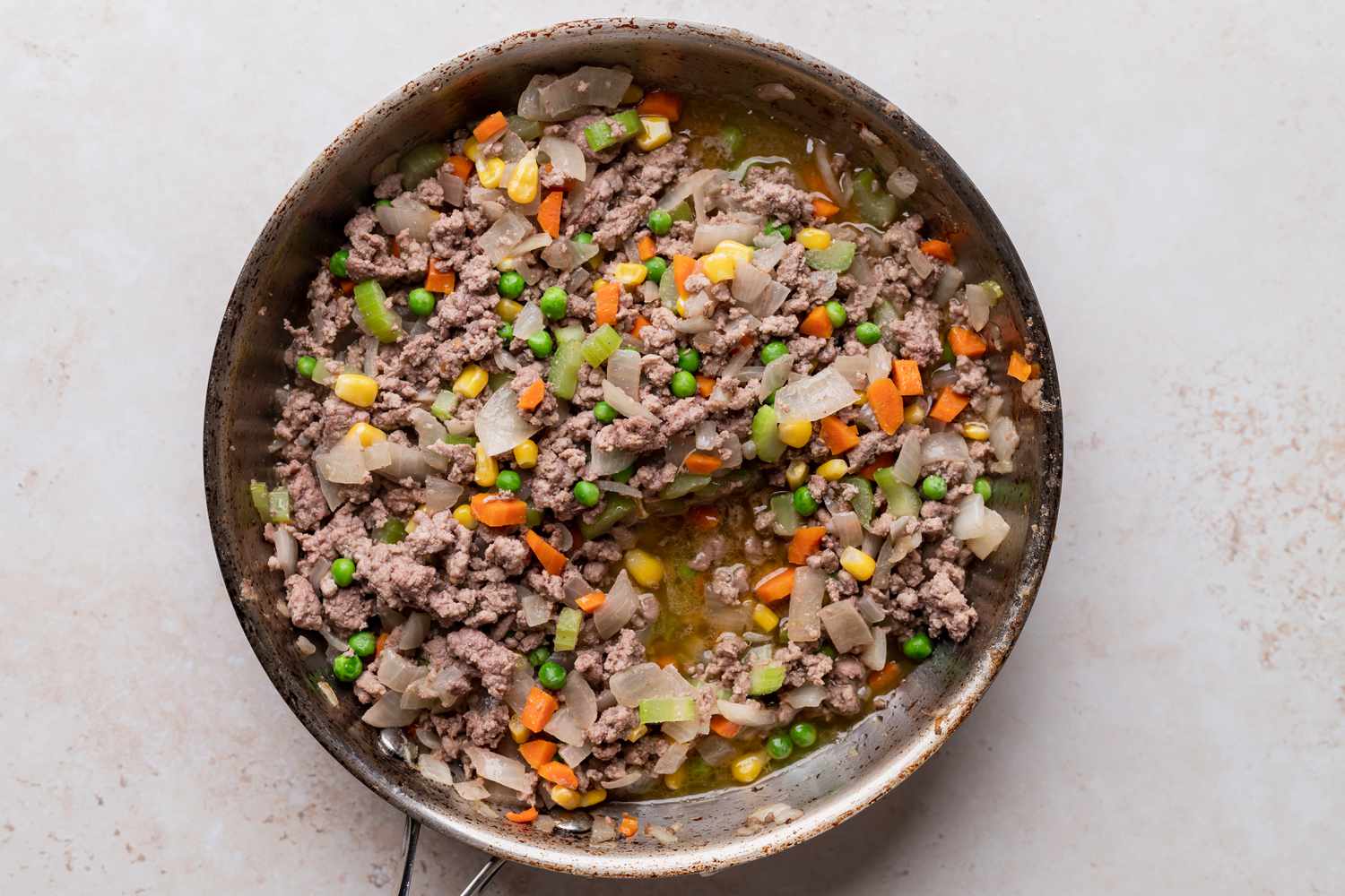 Beef broth added to the skillet to make a shepherds pie recipe.