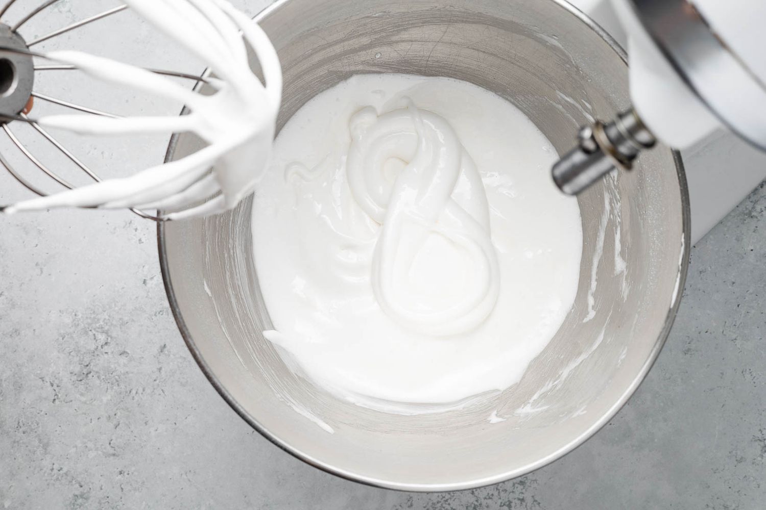Soft meringue in a stand mixer bowl (with a figure eight leftover from the consistency test) for ritz torte recipe