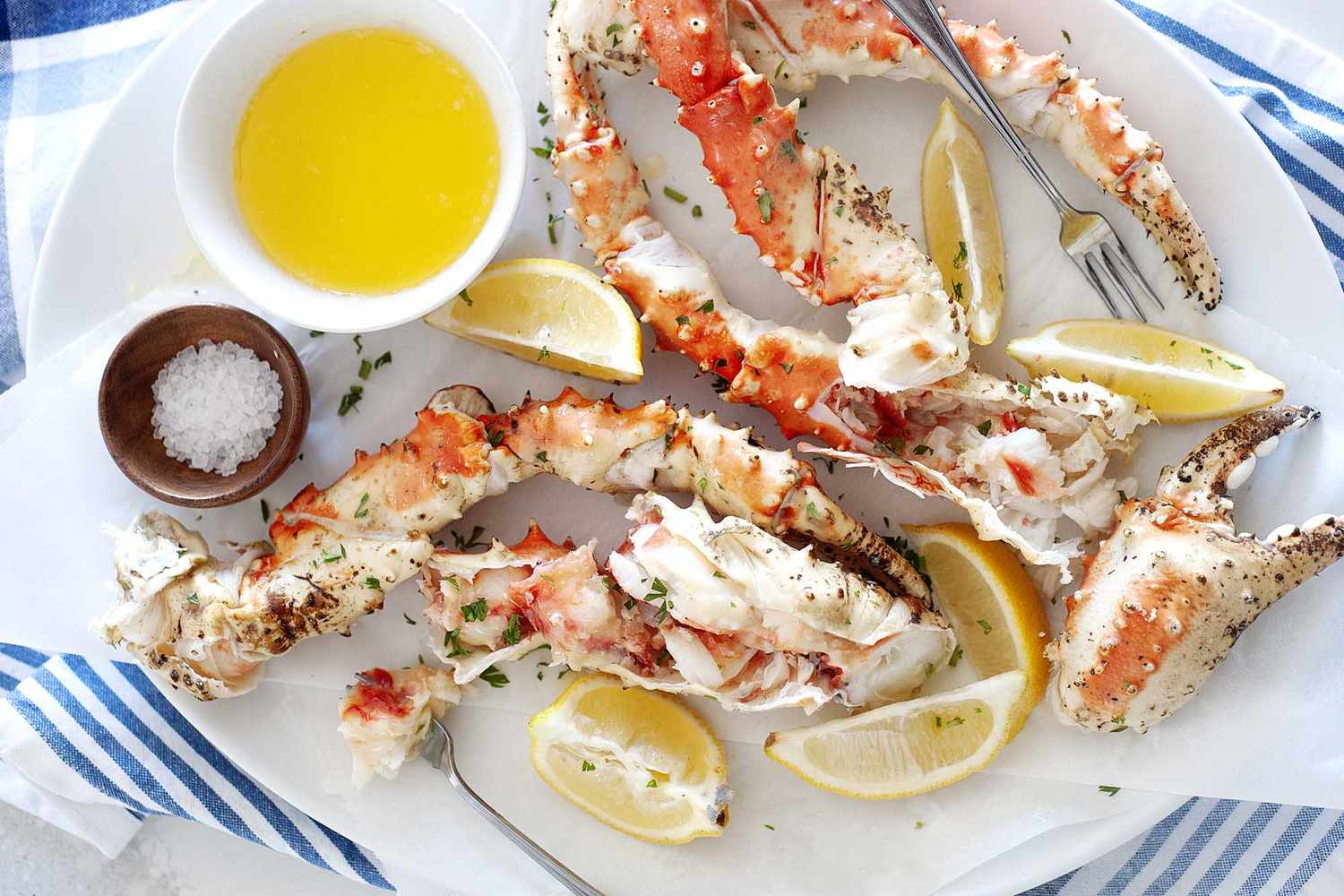 King crab on a platter with lemons, salt, and butter.