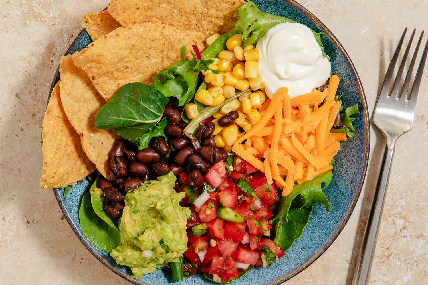 bowl of black bean nacho salad with a dollop of sour cream