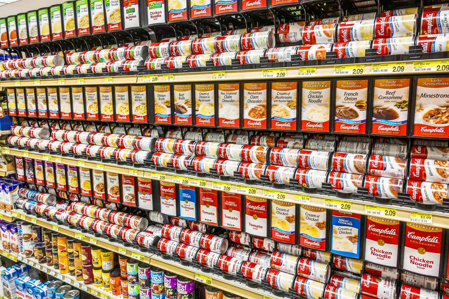 Store shelves stocked with various cans of Campbells soup