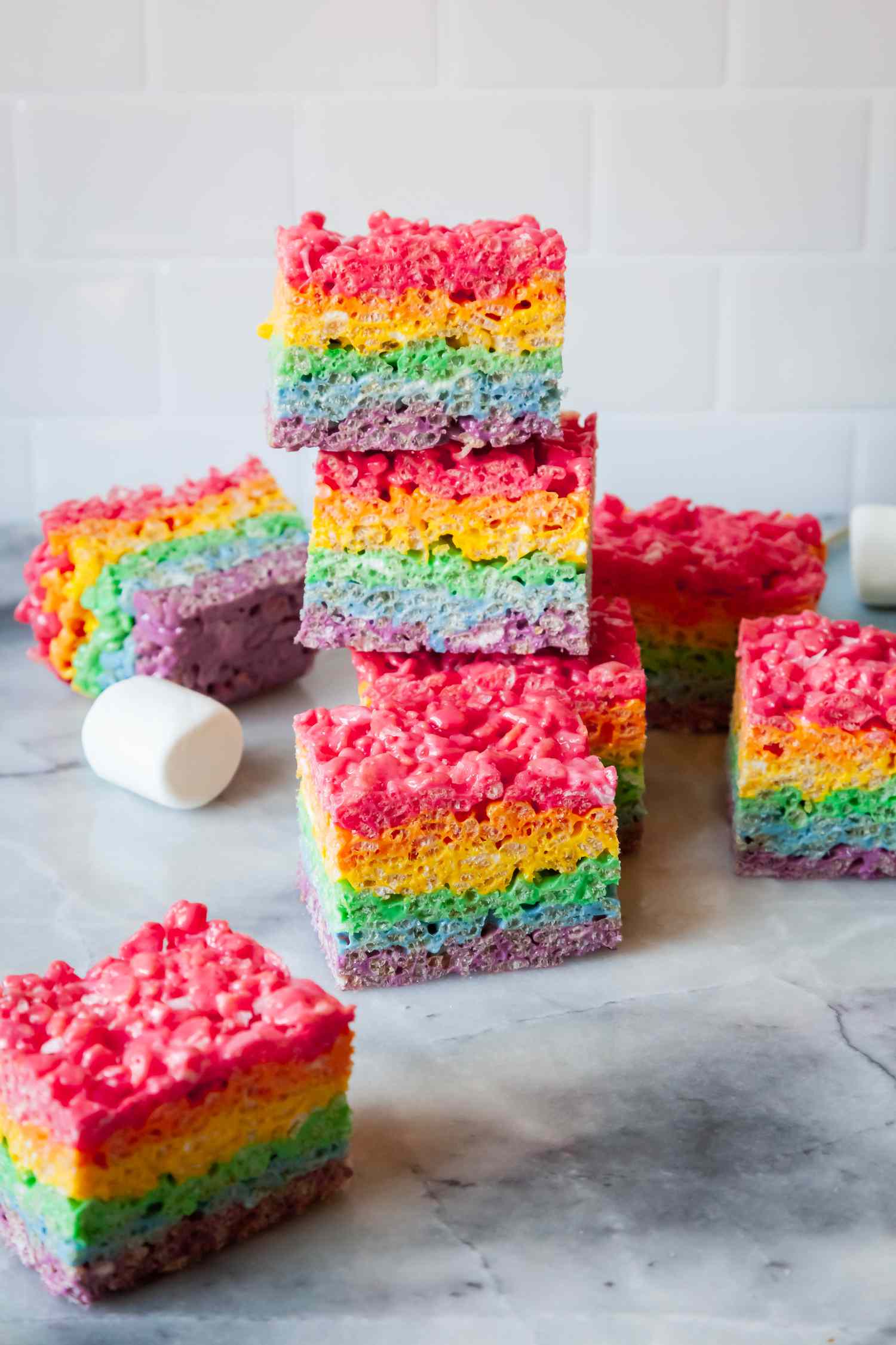 Rainbow Rice Krispies Treats Stacked Next to More Krispies Treats