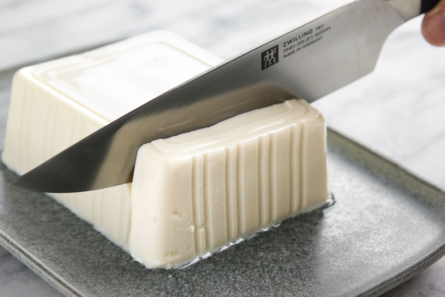 Knife Cutting into a Block of Silken Tofu for 5-Minute Silken Tofu Recipe