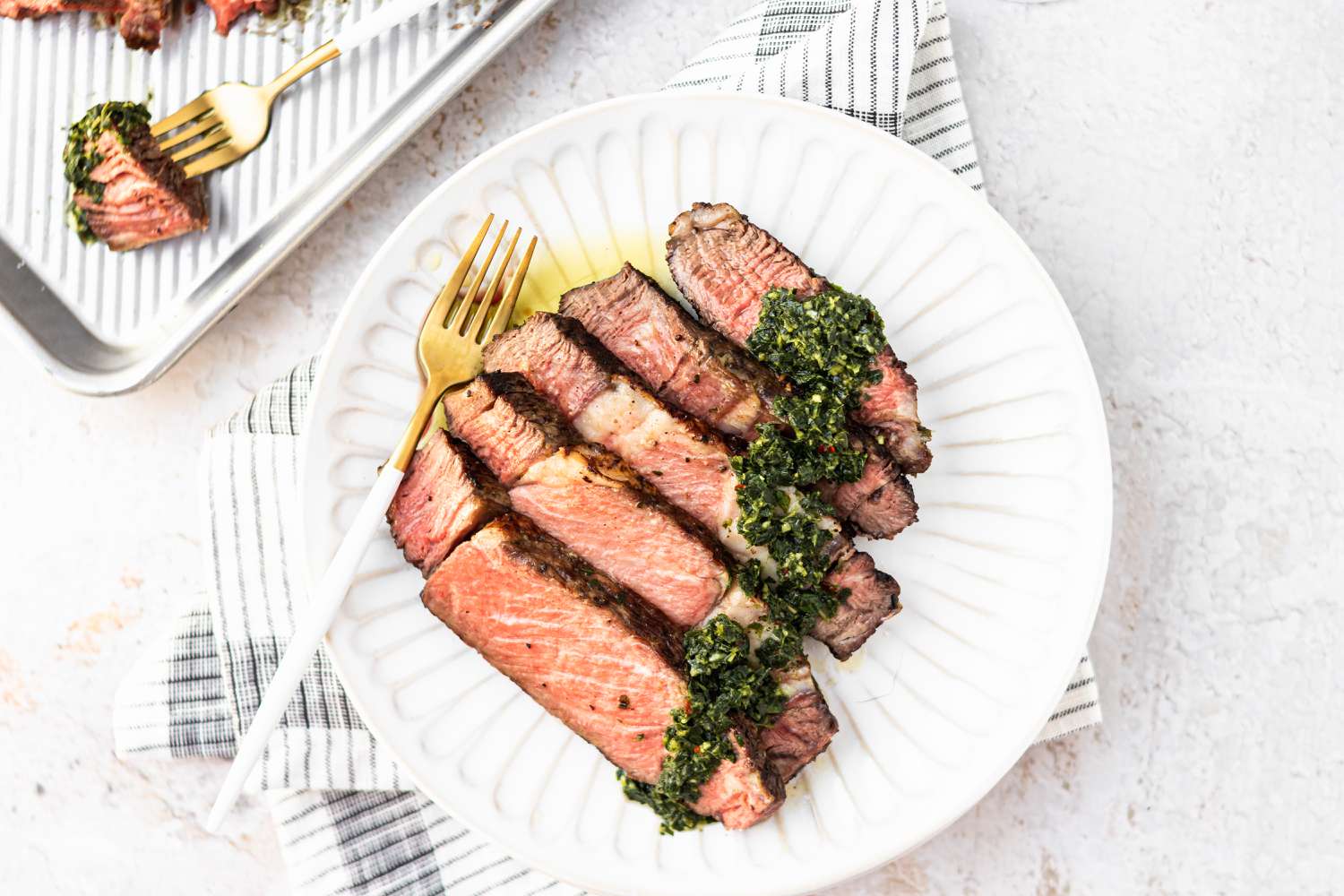 Overhead view of a plate of sliced cowboy steak.