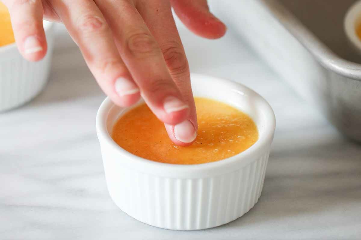 A finger checking the Creme Brulee Custard