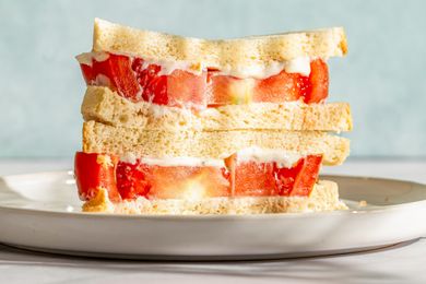 A tomato sandwich stacked, served on a plate
