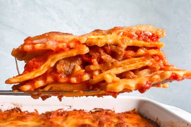 4-ingredient ravioli lasagna lifted from a casserole dish using a spatula