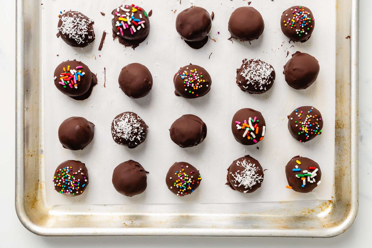 Sheet pan with chocolate covered potato candy topped with various toppings