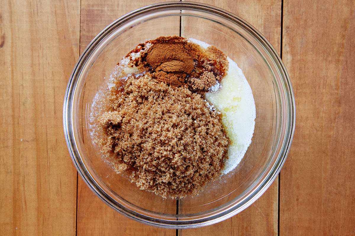 A glass bowl has spices, melted butter and brown sugar in it for a homemade king cake filling.